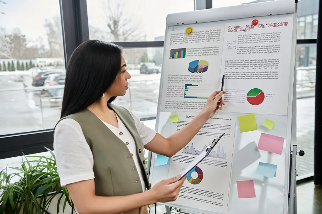 Adobe Stock Photo of a young woman pointing with a pen at a poster board